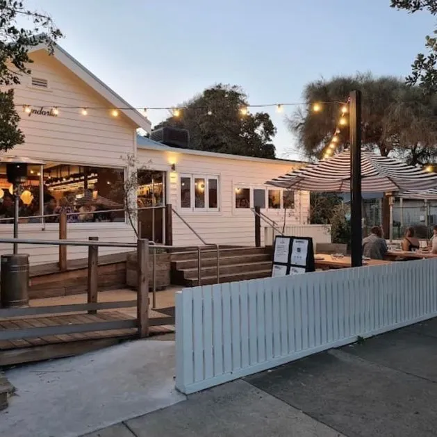 Cozy restaurant with outdoor seating and string lights at dusk.