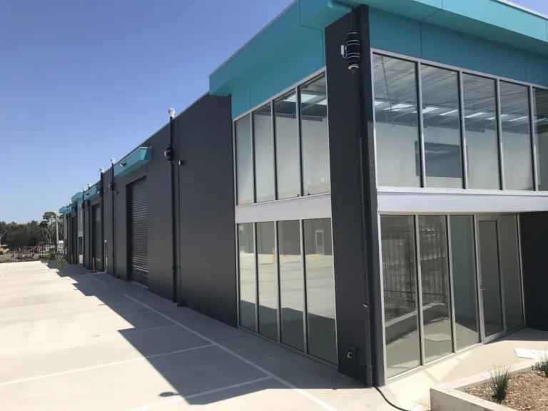 Modern industrial building with large windows and blue accents.