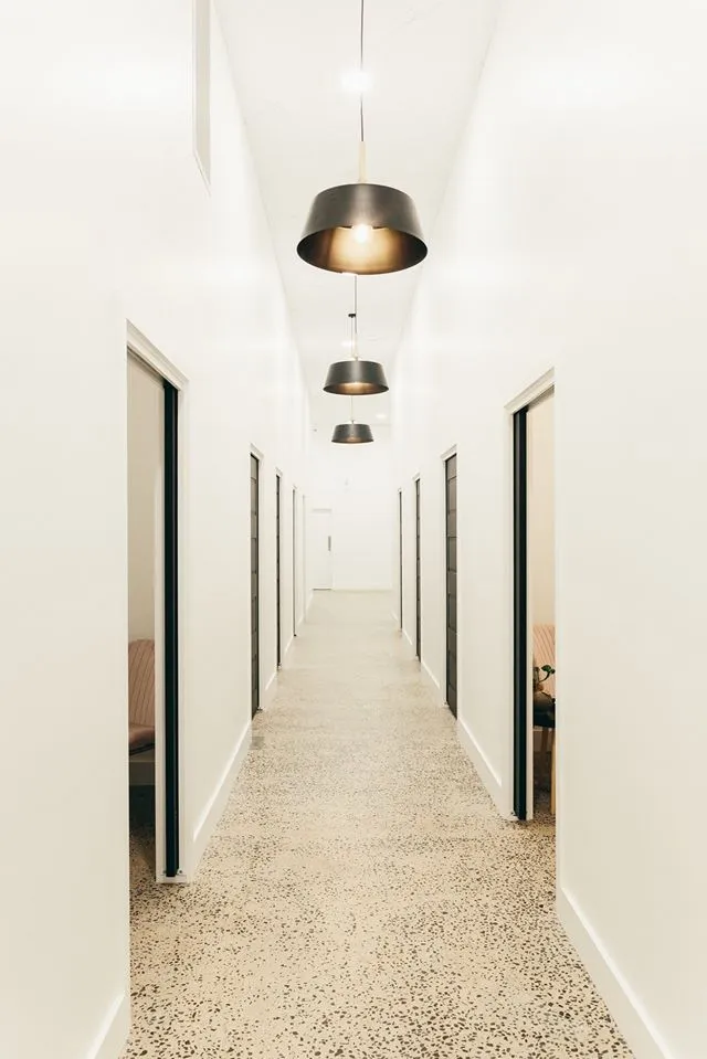 Modern corridor with pendant lights and terrazzo flooring.